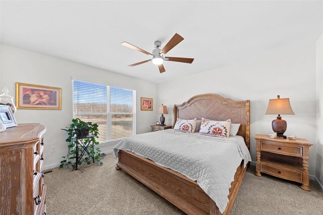 bedroom featuring baseboards, light colored carpet, and a ceiling fan