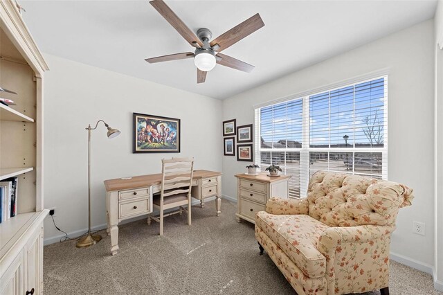 home office featuring light colored carpet, baseboards, and ceiling fan