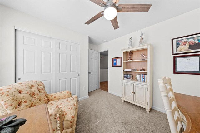 sitting room with ceiling fan, baseboards, and light carpet