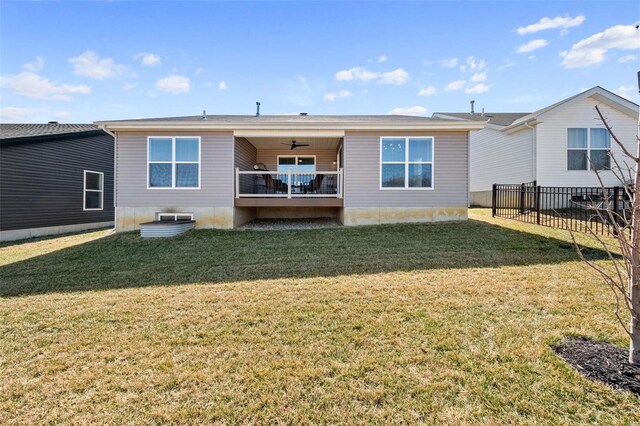 back of house with a yard, a ceiling fan, and fence