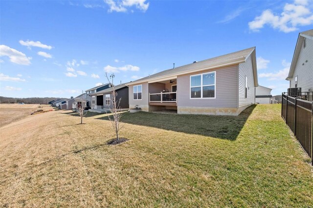 back of house featuring central AC unit, a yard, and fence