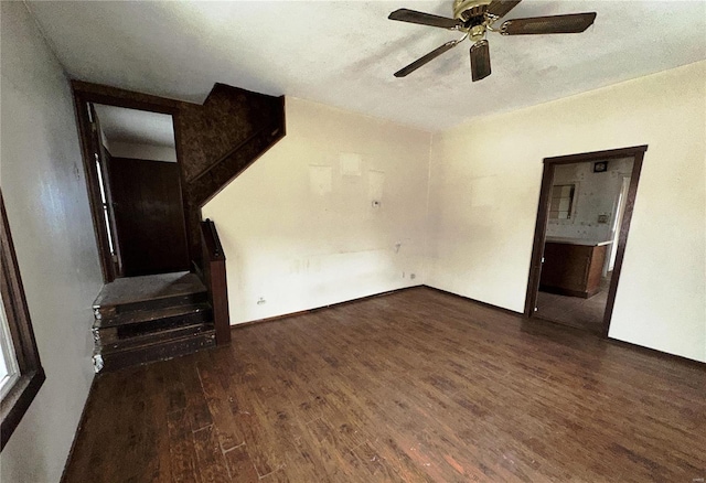 unfurnished living room with a textured ceiling, dark wood finished floors, and a ceiling fan