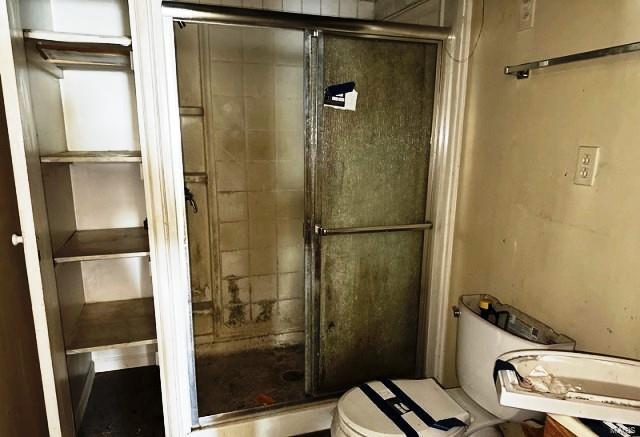 full bathroom with a stall shower and toilet