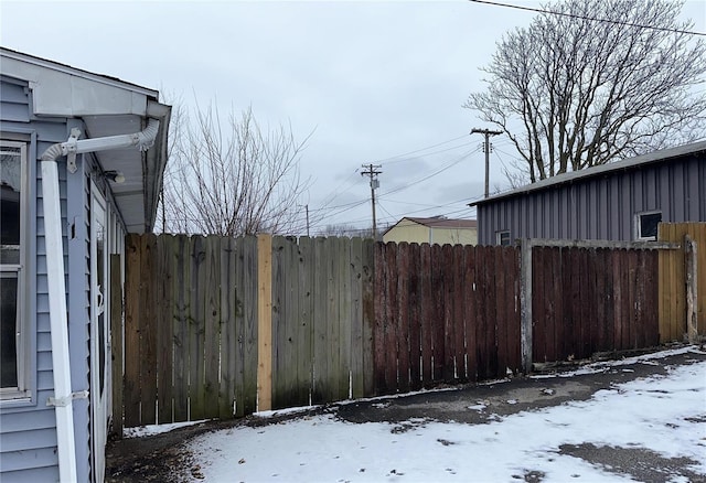 snowy yard featuring fence