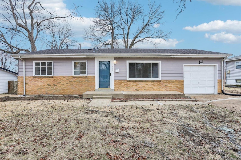 single story home with a garage and brick siding