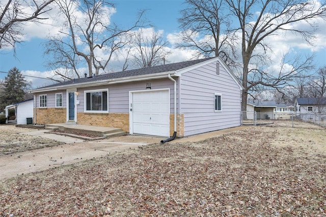 view of front facade with a garage, brick siding, and fence