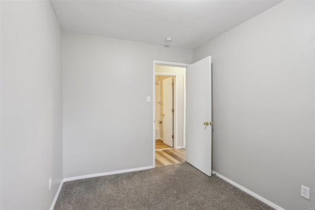 empty room with baseboards and light colored carpet