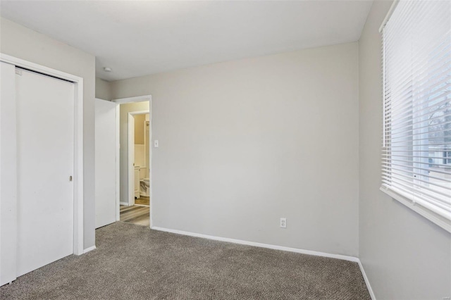 unfurnished bedroom featuring carpet, baseboards, and a closet