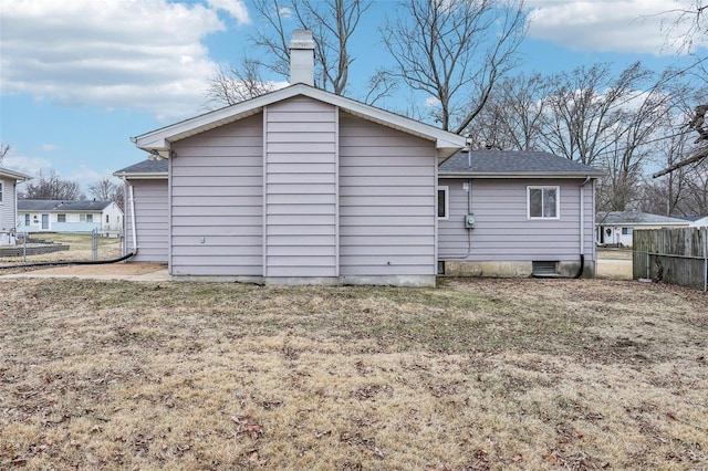 back of property with roof with shingles, a lawn, and fence