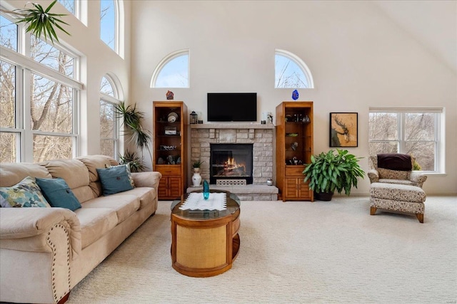 living room with carpet floors, a fireplace, and a towering ceiling