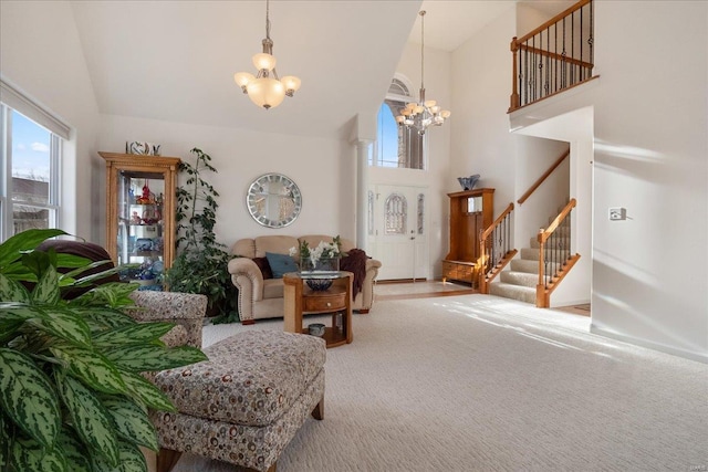 living room with baseboards, a towering ceiling, stairway, carpet floors, and a chandelier