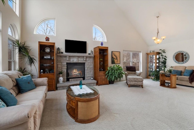 living area featuring a wealth of natural light, a glass covered fireplace, and a high ceiling