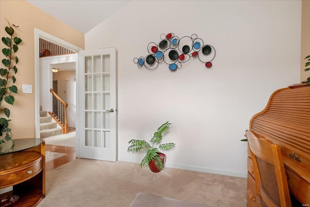 interior space with light carpet, french doors, stairway, and vaulted ceiling