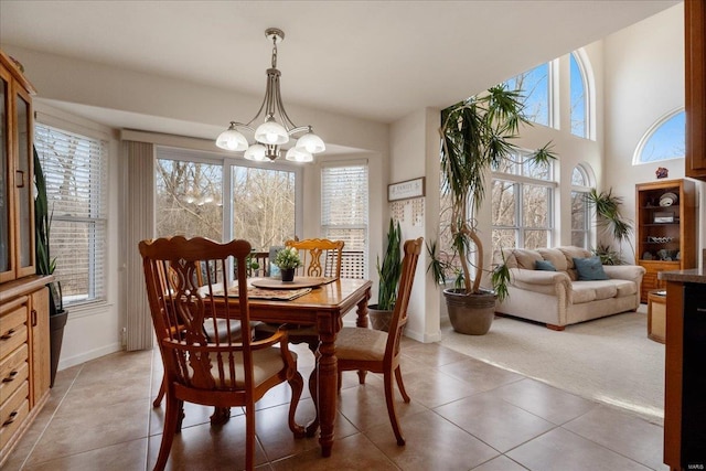 dining space featuring tile patterned floors, a healthy amount of sunlight, carpet flooring, and an inviting chandelier