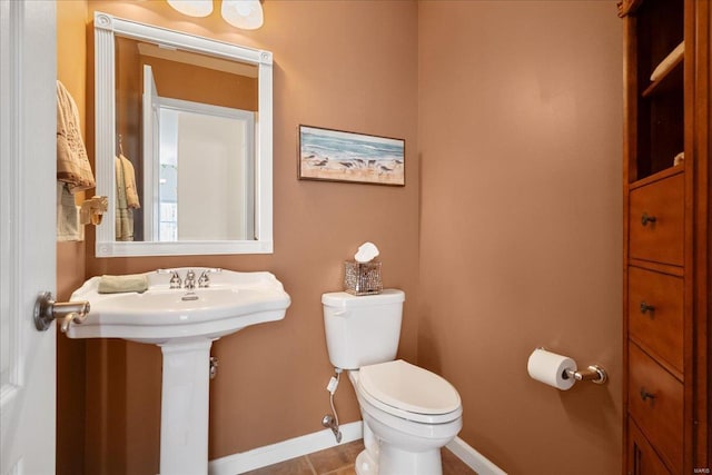 half bathroom featuring toilet and baseboards