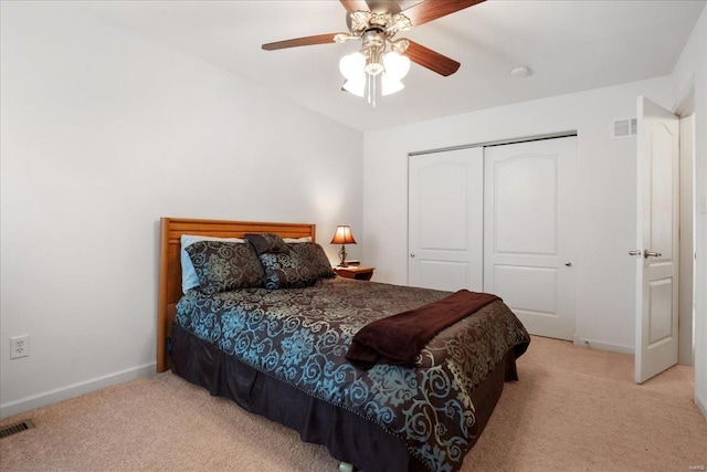 bedroom featuring a closet, visible vents, and light colored carpet