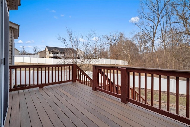 wooden terrace with a fenced backyard