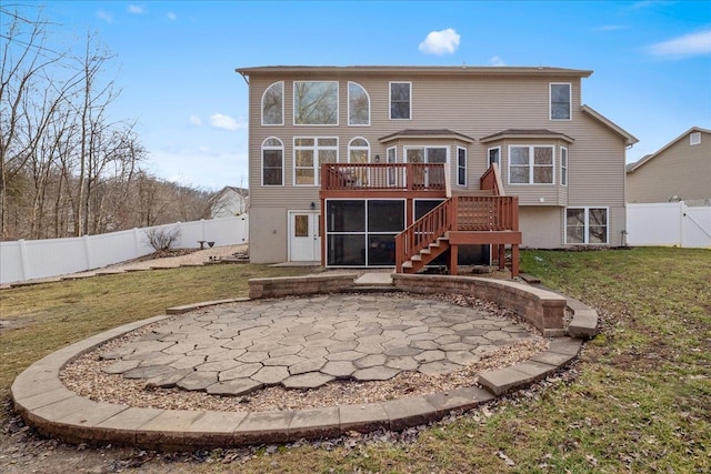 rear view of house with a deck, a fenced backyard, a yard, and stairway