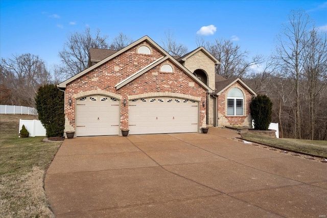 view of front of home with concrete driveway, roof with shingles, an attached garage, fence, and brick siding