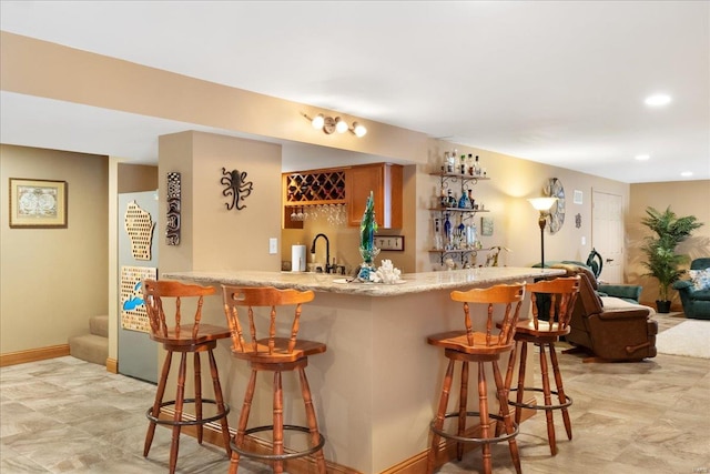 bar featuring recessed lighting, a sink, baseboards, stairs, and wet bar