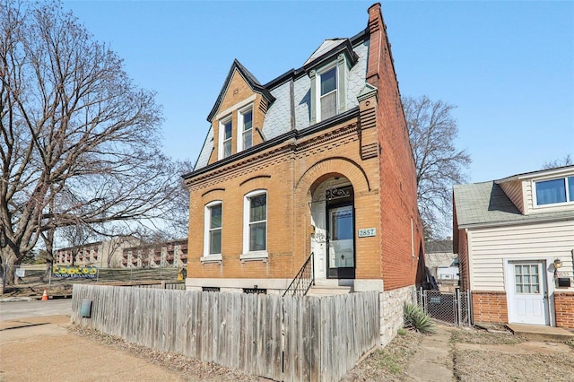 view of front of house with a fenced front yard, a gate, and brick siding