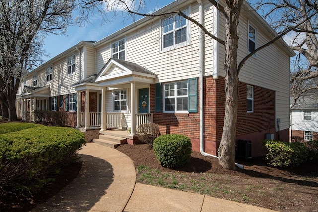 view of front facade featuring central AC unit and brick siding