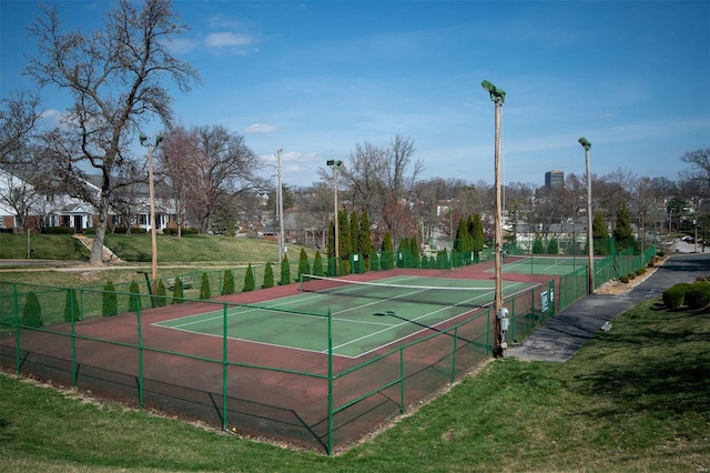 view of sport court with a yard and fence