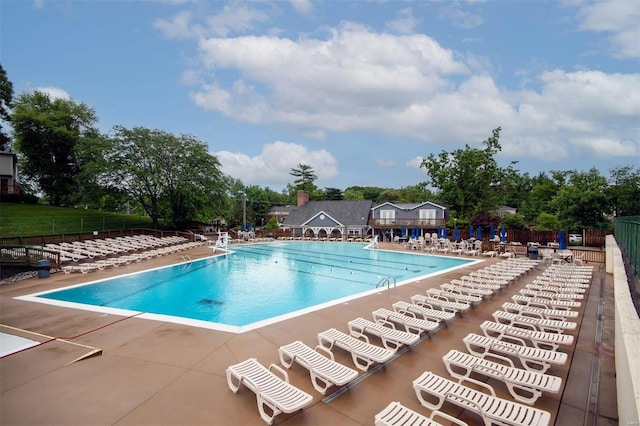 community pool featuring fence and a patio