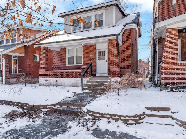 bungalow-style home featuring brick siding and a balcony