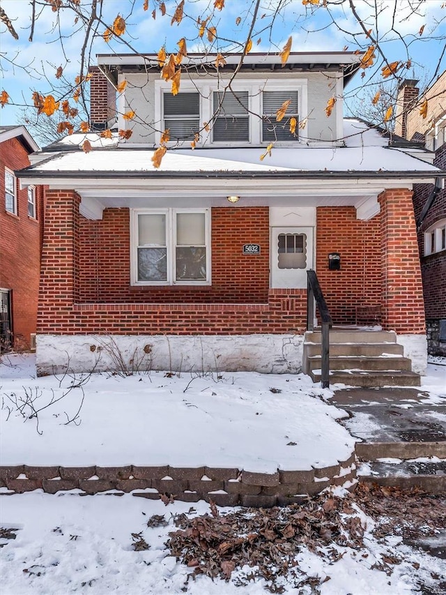 view of front of home featuring brick siding, cooling unit, and a balcony