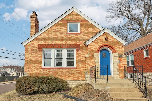 view of front of home with brick siding and a chimney