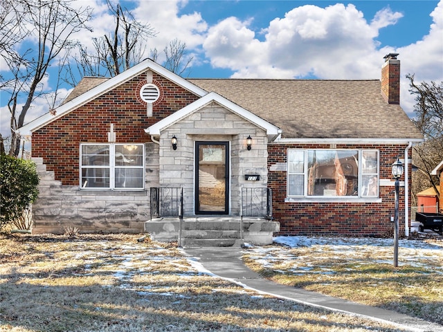 view of front of house featuring stone siding, brick siding, a chimney, and a shingled roof