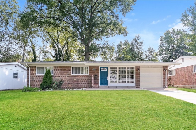 single story home featuring a garage, concrete driveway, brick siding, and a front lawn