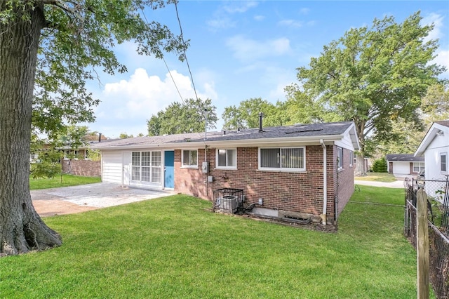 rear view of property with a yard, fence, a patio, and brick siding