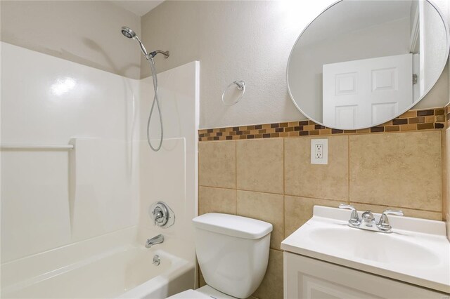 bathroom with tile walls, tub / shower combination, vanity, and toilet