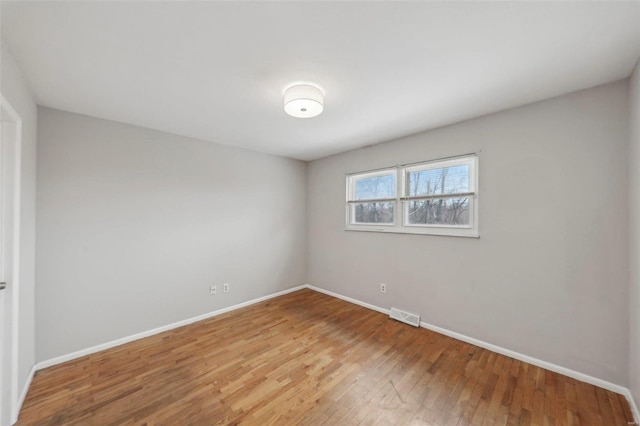 unfurnished room featuring visible vents, baseboards, and wood finished floors