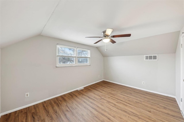 additional living space featuring wood finished floors, visible vents, and baseboards