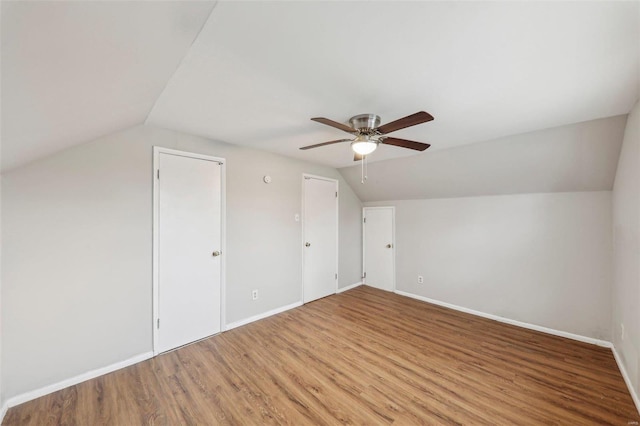 additional living space featuring lofted ceiling, baseboards, a ceiling fan, and light wood-style floors