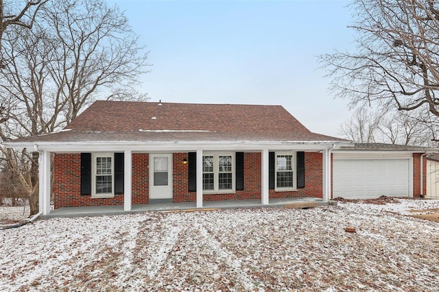 view of front of house with a garage, brick siding, roof with shingles, and covered porch