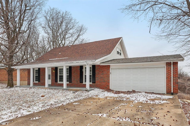 view of front facade with an attached garage, covered porch, roof with shingles, and brick siding