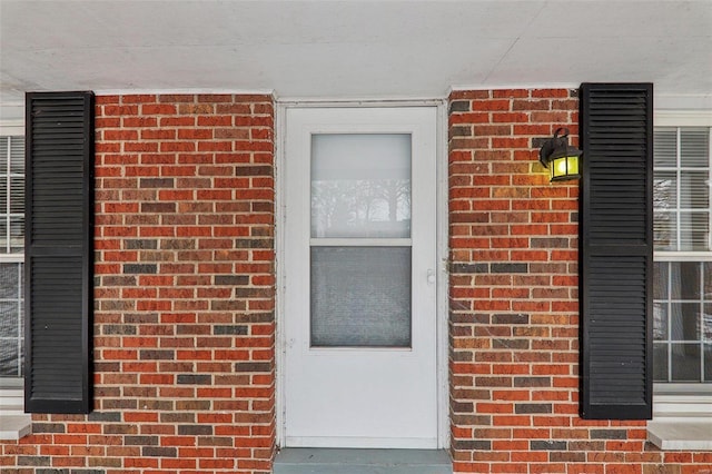 view of exterior entry with brick siding