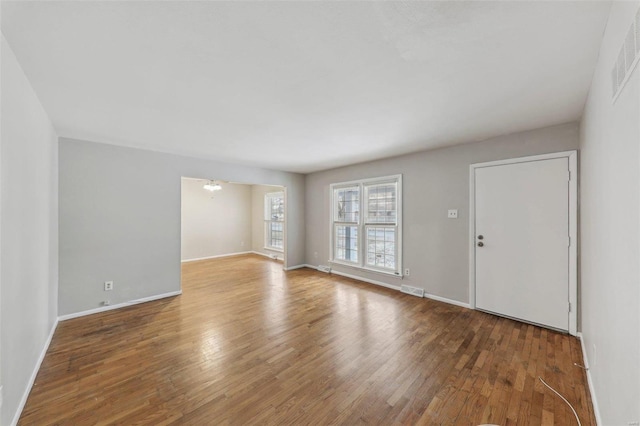 interior space with wood finished floors, visible vents, and baseboards