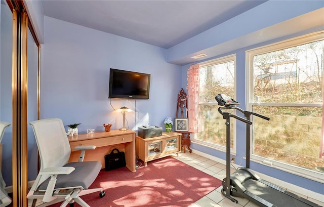 office area with light tile patterned floors, plenty of natural light, visible vents, and baseboards