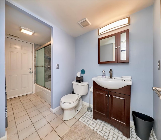 bathroom with toilet, bath / shower combo with glass door, vanity, and visible vents