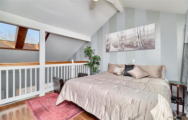 bedroom featuring vaulted ceiling with skylight and wood finished floors