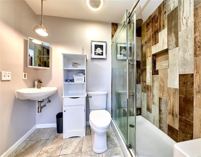 full bath featuring a sink, a shower stall, toilet, and baseboards