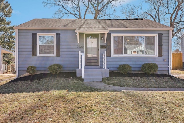 bungalow featuring a shingled roof and a front yard