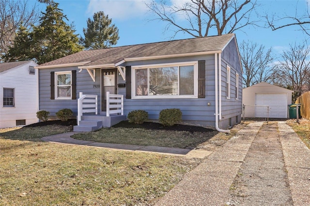 bungalow-style house featuring an outbuilding, driveway, a front yard, and a garage