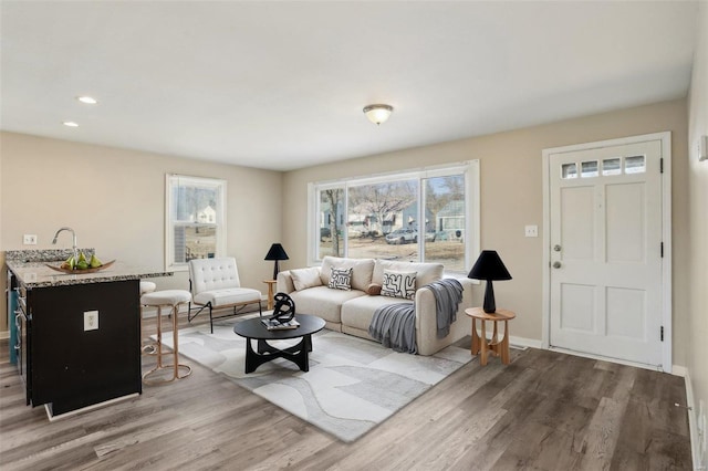 living room with recessed lighting, baseboards, and wood finished floors