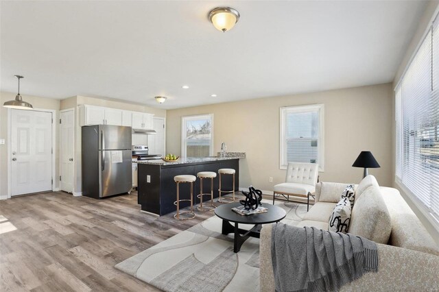living room with plenty of natural light, wood finished floors, and baseboards
